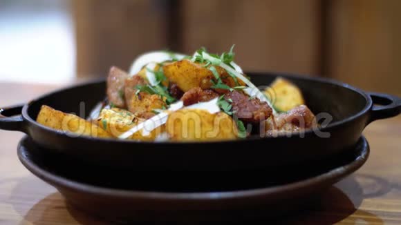 奥贾胡里格鲁吉亚一家餐馆的木桌上用煎锅里的肉烤土豆视频的预览图