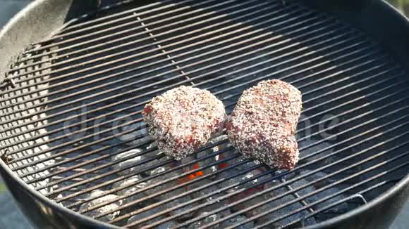 把热肉牛排翻过来加香料在烤炉外烤火焰煤火烧得很近视频的预览图