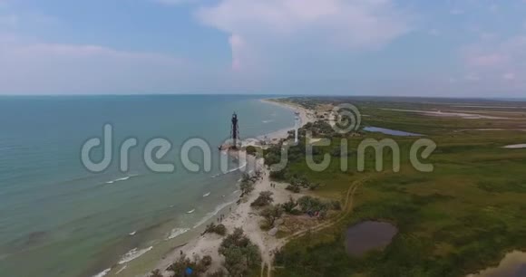 一个令人惊叹的空中景色白色灯塔和一座黑色边境塔在Dzharylhach岛上美丽的海岸被覆盖视频的预览图