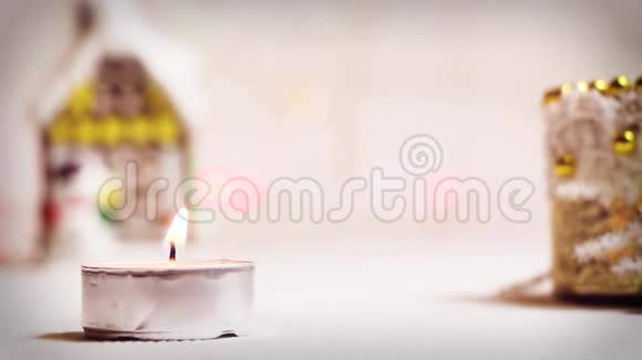 在新年玩具冬屋的背景上点燃一支浅色蜡烛视频的预览图