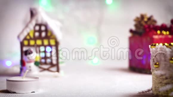 在新年背景下点燃蜡烛有一个冬天的房子一个圣诞天使和礼品盒视频的预览图