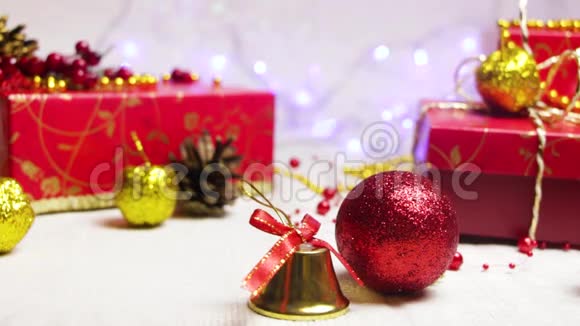 手工制作的红色礼品盒和新年装饰品金色的苹果一个凸起和一个铃铛里面有闪烁的灯笼视频的预览图