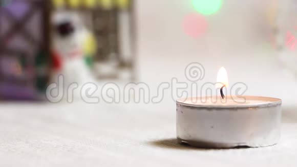 在新年的房子和闪烁灯笼的背景下燃烧蜡烛特写视频的预览图