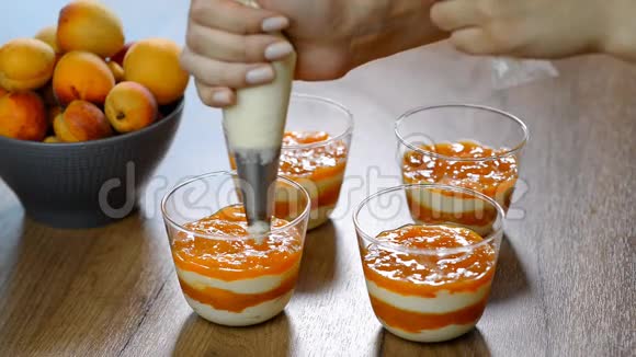 女人用手把糕点袋里的奶油挤在玻璃杯里视频的预览图