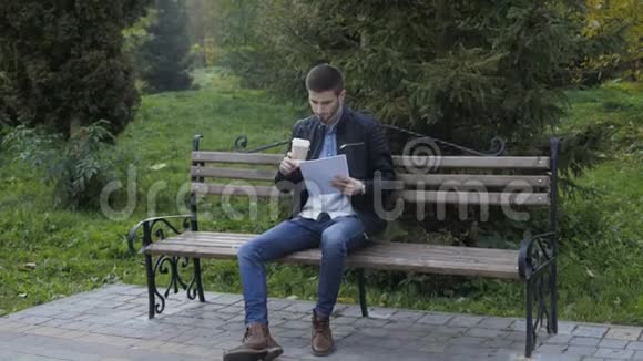 帅哥在公园4K喝咖啡和写论文视频的预览图