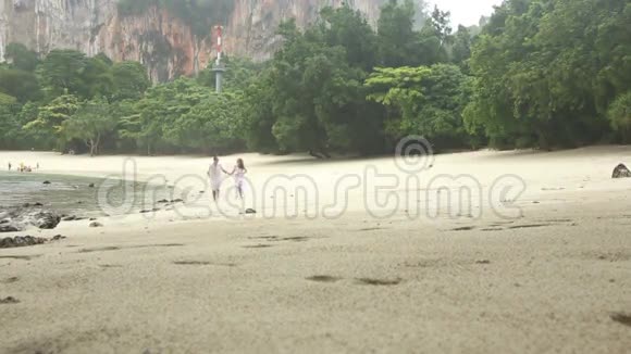 新娘和新郎在雨下沿海滩奔跑视频的预览图