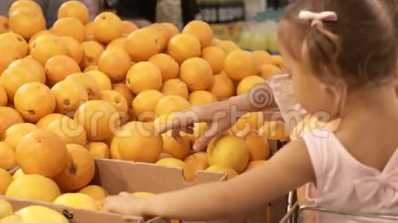 妈妈和小女儿在超市挑选水果的特写镜头视频的预览图