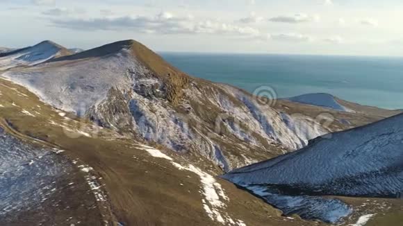 在多云的天空背景下鸟瞰雪山碧海射击冰岛海边的雪山视频的预览图
