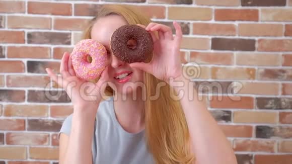 微笑女孩与甜甜圈玩得开心的特写镜头视频的预览图