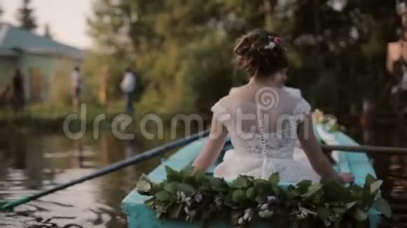 情侣们在婚礼上玩得很开心一对恋爱中的夫妻在一艘蓝色的船上停泊在河岸上扫帚桨视频的预览图