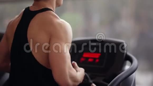 一个运动强壮的男人在跑步机上跑步强壮的肩膀手臂和背部在体育俱乐部工作视频的预览图