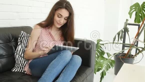 个人小玩意的概念家里拿着平板电脑的年轻女子视频的预览图
