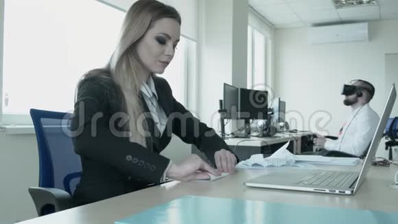 闲在上班族休息一个女孩在笔记本电脑附近做飞机一个年轻人在后台视频的预览图