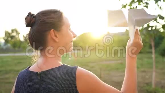 女人在日落的背景下发射纸飞机梦想旅行或职业的概念视频的预览图