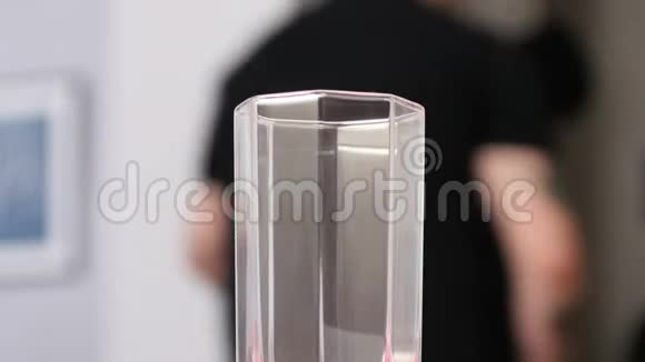 男士背景下的近距离透明玻璃支架视频的预览图