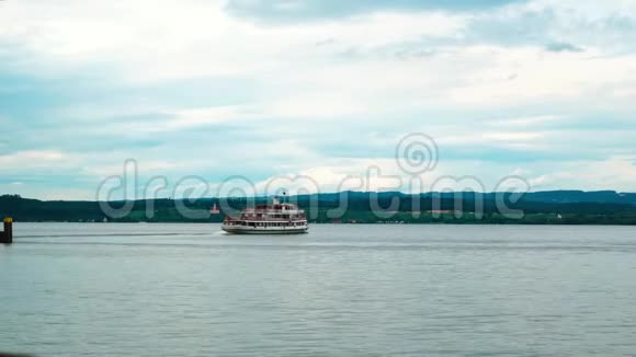 一艘有人的船从Mainau岛驶向梅尔斯堡镇在地平线上看到了沃尔法赫茨基切视频的预览图