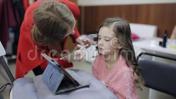 这个女孩是一个化妆大师她把嘴唇涂在一个模特儿上视频的预览图