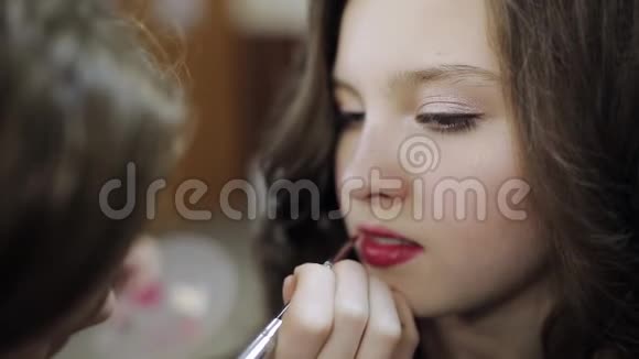 化妆师给美容院里的少女涂唇视频的预览图