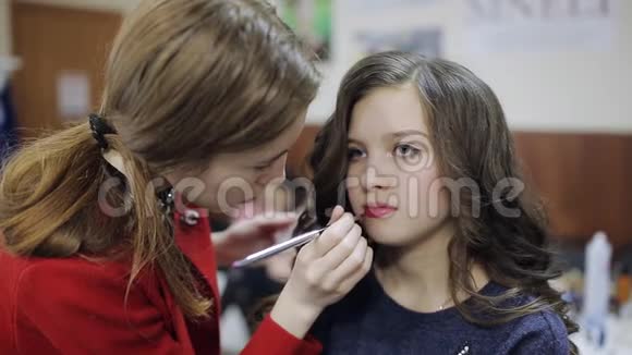 化妆师给美容院里的少女涂唇视频的预览图