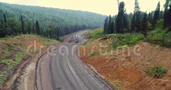 森林道路全景林中乡村道路上的倾卸车的鸟瞰图从泰加无人机的视野视频的预览图