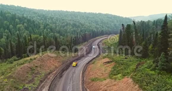 森林道路全景在森林中的乡村道路上的跳伞者的空中视野从泰加无人机的视野视频的预览图