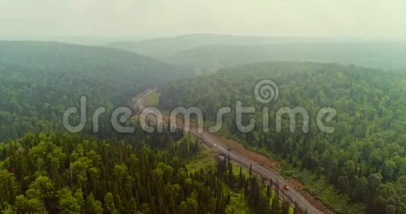 森林道路全景在森林中的乡村道路上的跳伞者的空中视野从泰加无人机的视野视频的预览图
