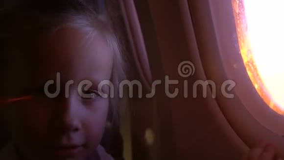 一个漂亮的小女孩在飞机窗户上视频的预览图