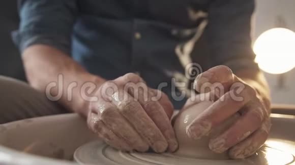 男人手沾上泥土用陶工轮子干活视频的预览图