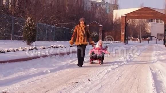 妈妈用雪橇把孩子卷起来视频的预览图