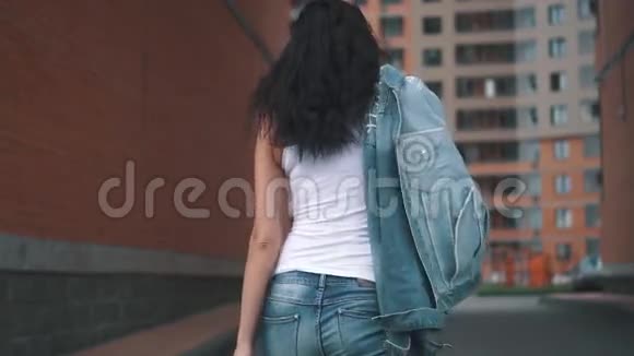 年轻迷人的女孩在街上散步一个夏天穿着牛仔裤和t恤在城市里走来走去的黑发女人视频的预览图
