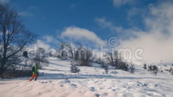 一个女孩正走在白雪覆盖的森林里徒步旅行冬季景观视频的预览图