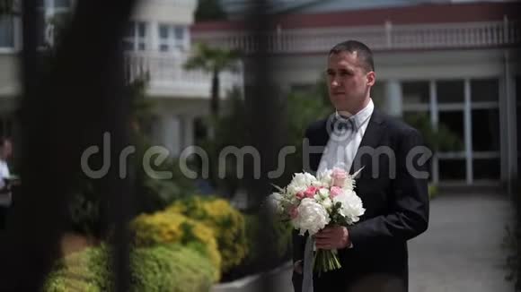 年轻漂亮的新娘穿着婚纱去新郎那里新婚夫妇的会面视频的预览图