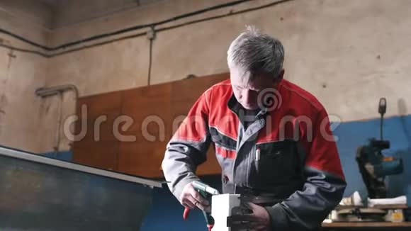 工人用螺丝刀组装手册中的金属部件视频的预览图