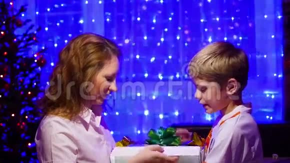 圣诞礼物惊喜一个孩子和女孩打开礼物与魔术明星背景中bokeh灯和花环视频的预览图