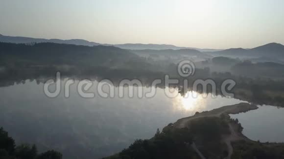 电影院的空中飞过一个山湖上空的晨雾雾蒙蒙的日出视频的预览图