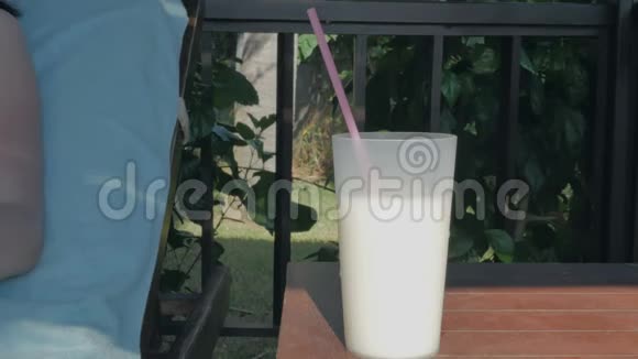 活跃的年轻女孩在海滩上喝一杯鸡尾酒在游泳池旁的休息室里视频的预览图