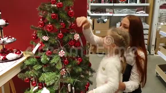 年轻女子在商店里挑选圣诞树装饰品视频的预览图