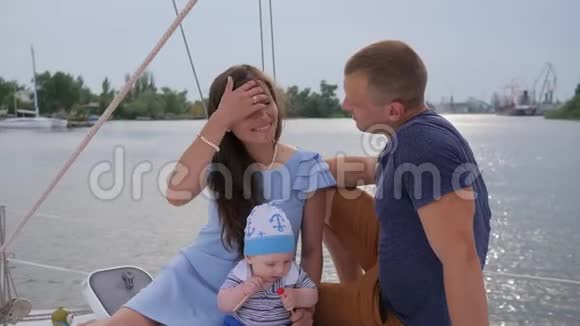 带着妻子和孩子在湖边微笑的男人带着孩子在游艇上放松的好夫妇带着婴儿的丈夫和伴侣视频的预览图