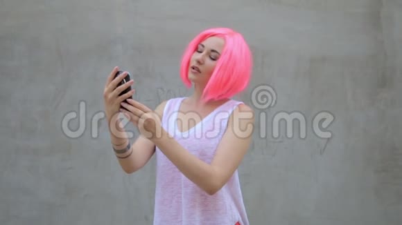 美丽的混血女人粉红色假发自拍用电话微笑旋转享受生活视频的预览图