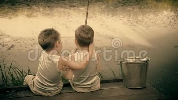 两兄弟在露天捕鱼男孩子们穿着白色的裙子钓鱼美丽的孩子们在夏天玩得很开心视频的预览图