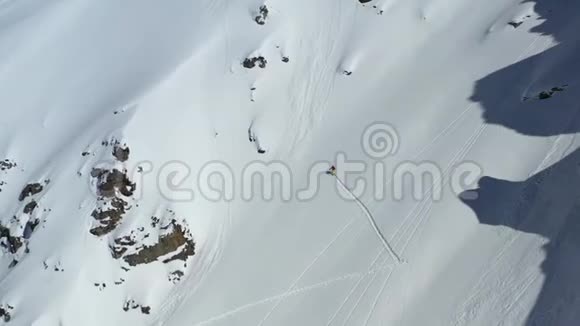一名男子在陡峭的积雪覆盖的山坡上滑雪空中拍摄4k的画面视频的预览图