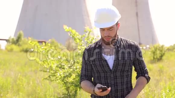 建筑工人在头盔和电话户外的肖像视频的预览图