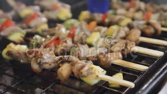 烧烤青蛙腿和蘑菇在串上在市场上烤肉和蔬菜很多烤肉视频的预览图