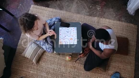 多种族夫妇坐在地板上玩棋盘游戏的俯视图女人扔骰子拿牌人等着转视频的预览图