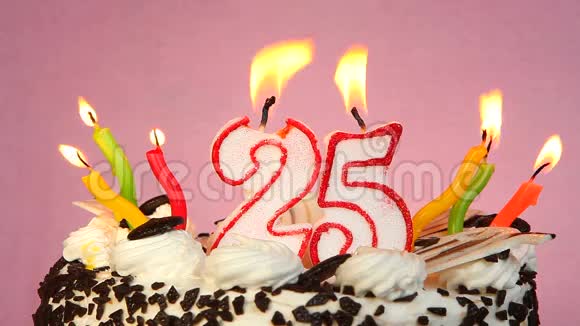 25年的生日蛋糕和蜡烛放在粉色背景上视频的预览图
