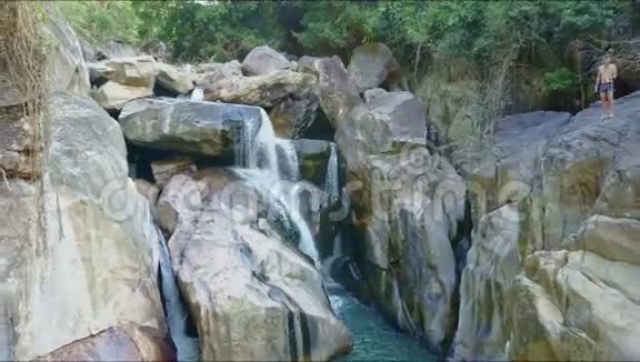 空中观景人在峡谷中的石头间跳入河中视频的预览图