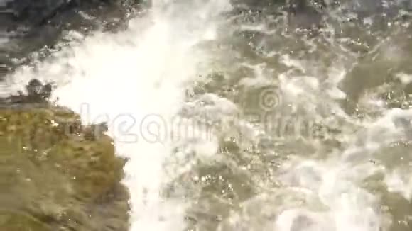 小山河快速的水流在石头之间流动形成白色的泡沫慢动作视频的预览图