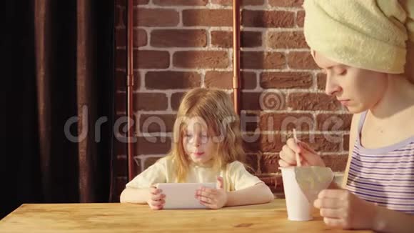 一个年轻的女人和一个小女孩在早餐时吃酸奶视频的预览图