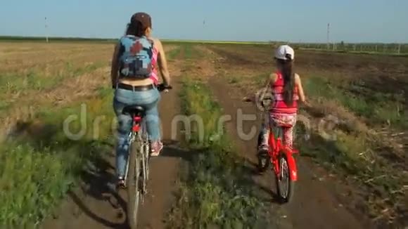 骑自行车带孩子的女人性质的体育家庭妈妈和女儿在乡下骑自行车视频的预览图