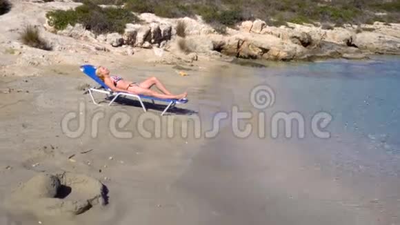 躺在沙滩上晒太阳的女人视频的预览图